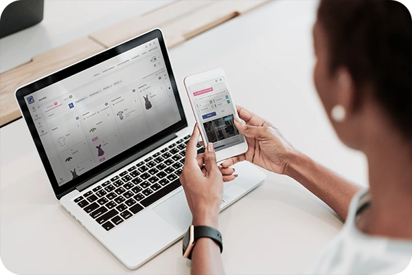 pessoa olhando o computador e o celular na mão, com o audaces isa na tela